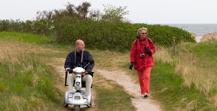 Couple experiencing accessible holiday using mobility scooter