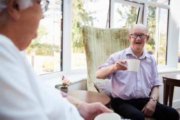 Man Talking to Elderly Disabled Man